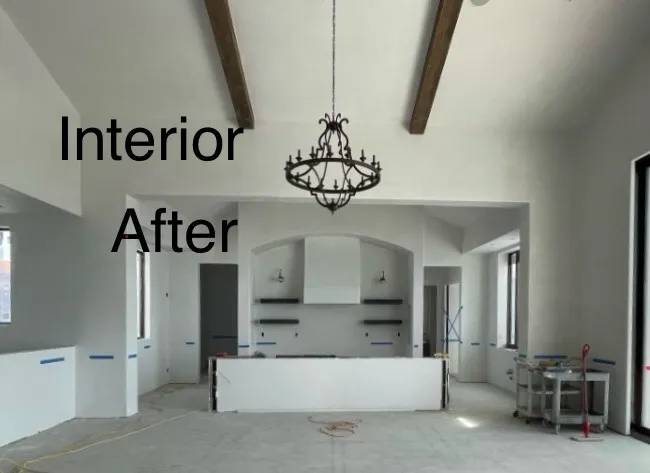 Finished interior with smooth plaster walls, wood beams, and chandelier (after)