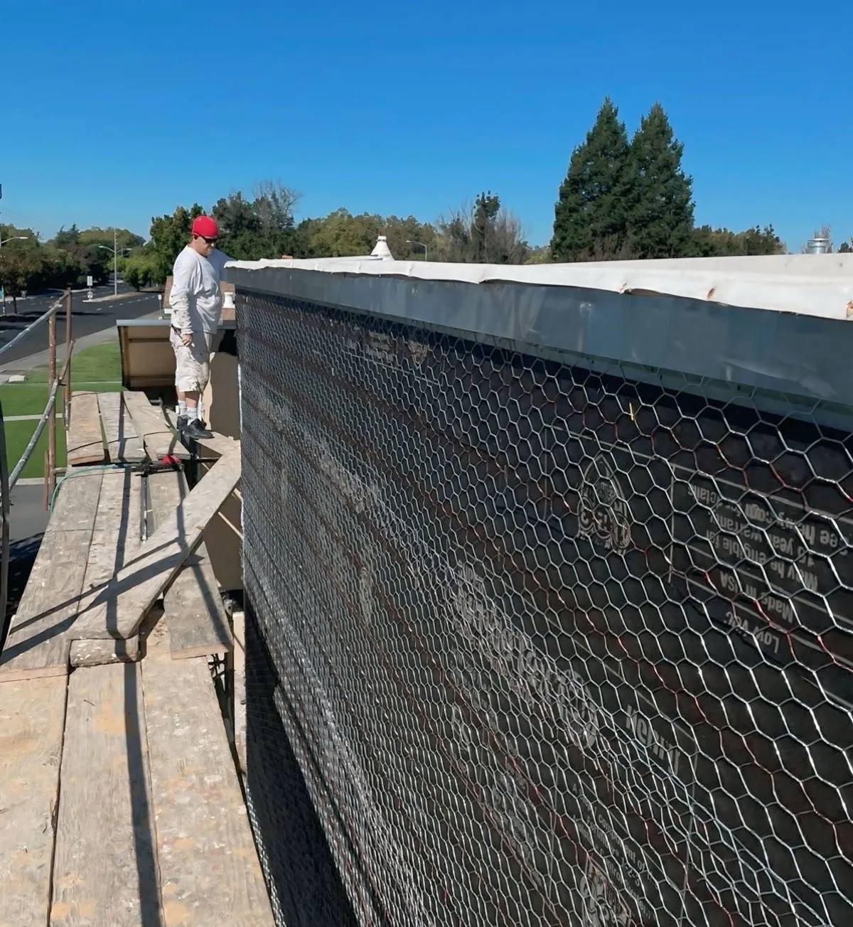 Wire lath and weather-resistive paper installed on a parapet wall ahead of stucco — waterproofing and moisture barrier work