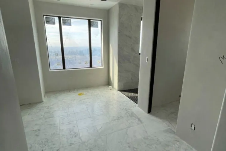 Venetian plaster walls and marble tile in a bathroom with a valley view — interior plaster finish