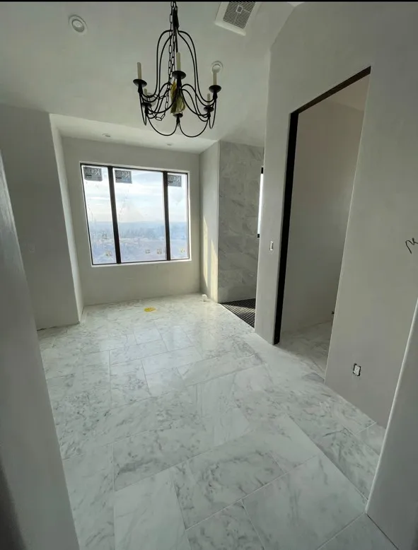 Room with venetian plaster walls, marble tile floor, and an iron chandelier — interior plaster finish